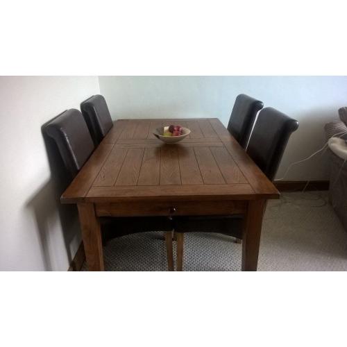 Extending Oak Dining Table and Four Brown Faux Leather Chairs