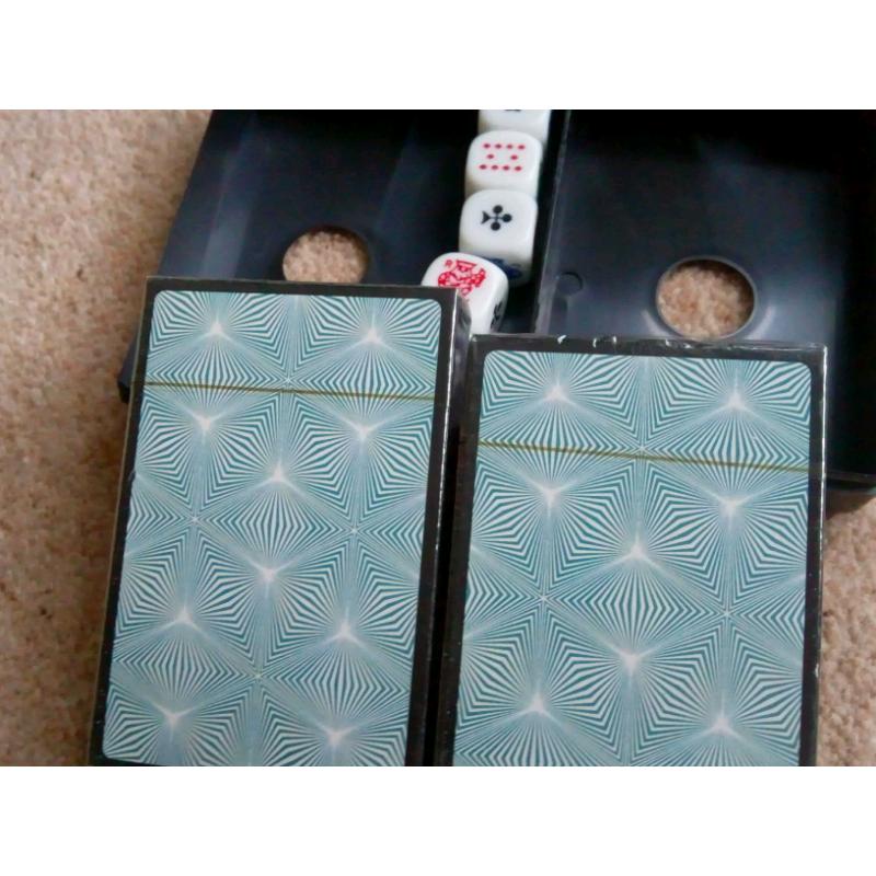Two packs of playing cards still in cellophane and 5 dice