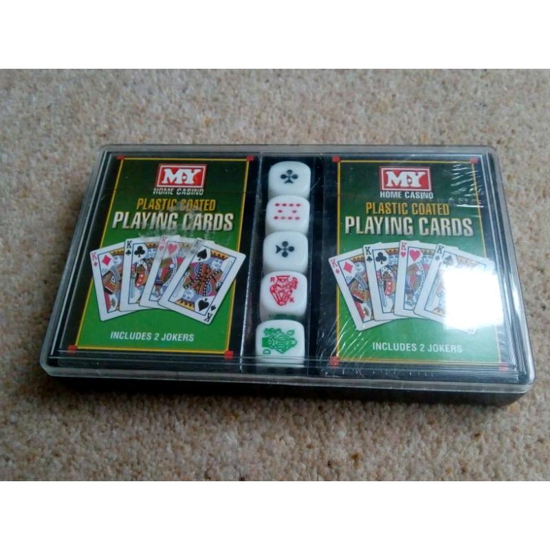 Two packs of playing cards still in cellophane and 5 dice