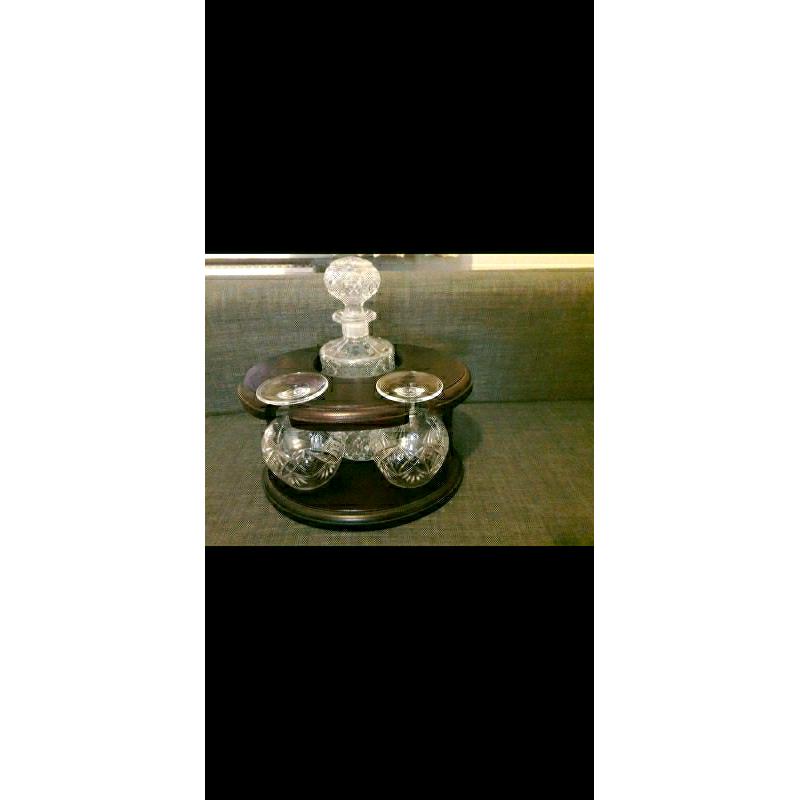 Decanter and 2 matching brandy glasses in dark wood display stand